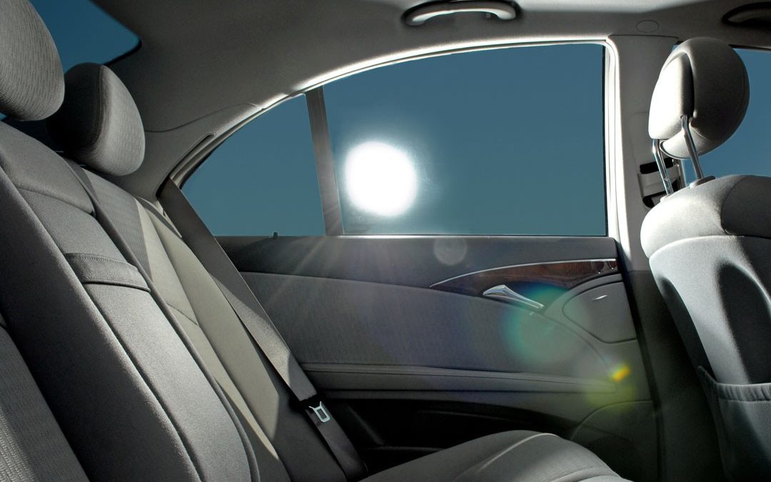 Inside of car with tinted windows and sun shining through from outside