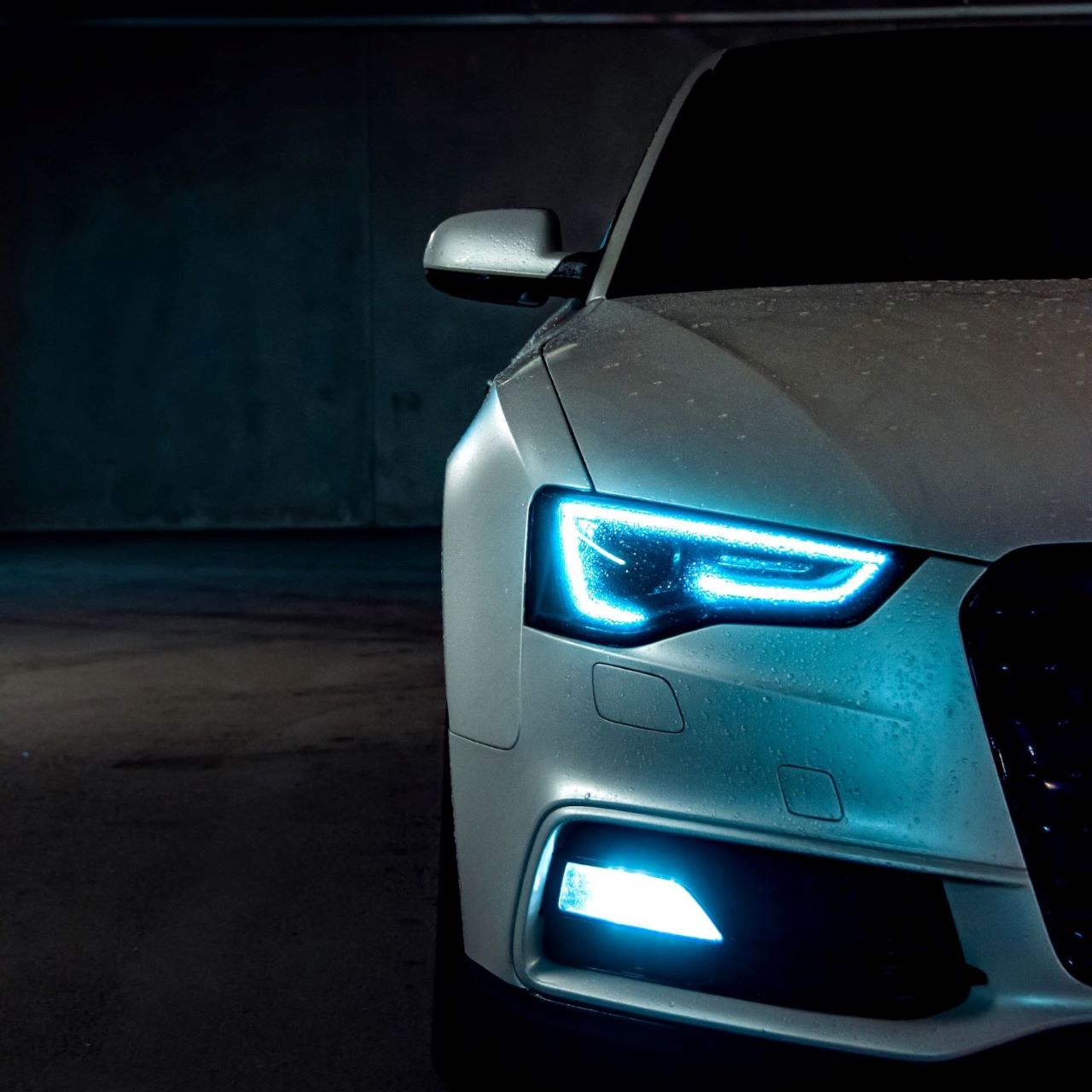 Audi with tinted headlights and blue lighting photographed at night