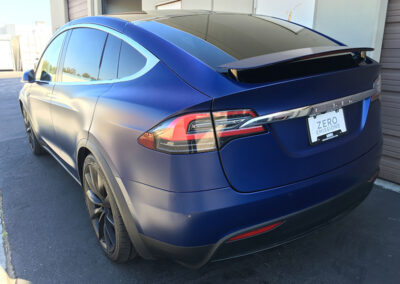 Rear of a blue satin Tesla Model X with stealth paint protection film