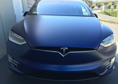 Front of a blue satin Tesla Model X with stealth paint protection film