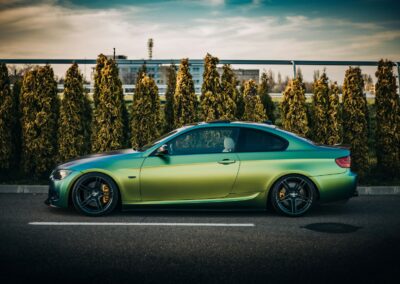 Green color-shift vinyl wrapped BMW coupe parked in San Diego
