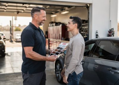 Customer and installer discussing window tinting cost inside a San Diego shop